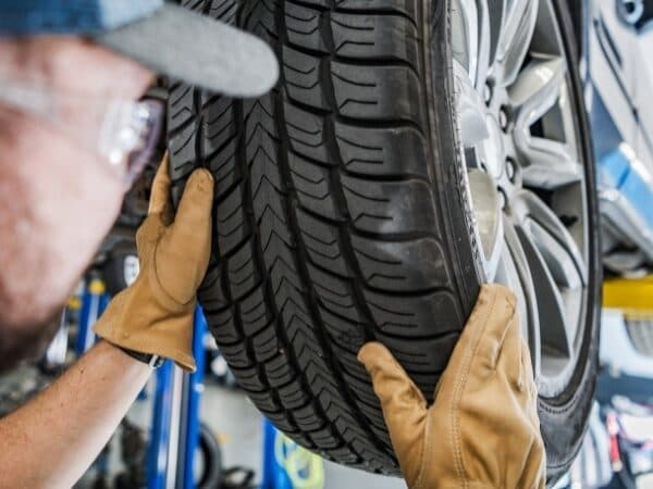 Un esperto in guanti protettivi sta smontando un pneumatico invernale per il cambio stagionale