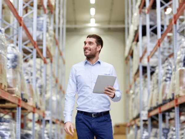 Un professionista che gestisce i servizi di magazzinaggio utilizzando un tablet per ottimizzare le operazioni logistiche