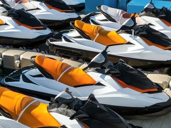 Gruppo di moto d'acqua bianche e arancioni pronte per il rimessaggio.