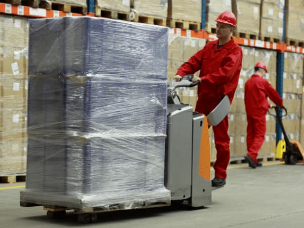 Lavoratori che movimentano merci in un magazzino, parte dei servizi di magazzinaggio