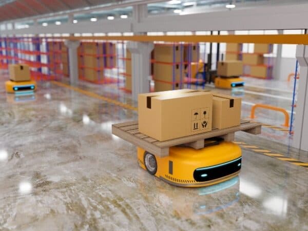 Robot di magazzino giallo che trasporta un pallet all'interno di un moderno magazzino automatizzato.